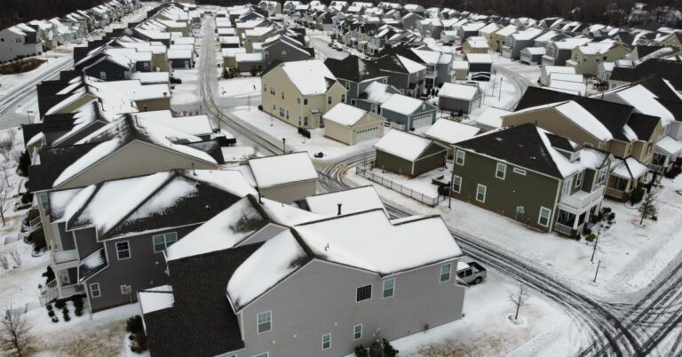 Aerial view of a snow-covered suburban neighborhood.