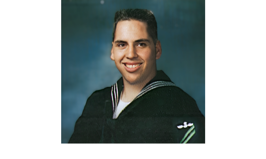 Headshot of a smiling man in a navy uniform.